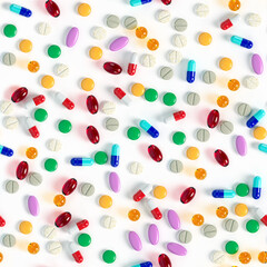 Seamless background of colourful tablets and pills on a white surface. Variety of vitamins. Production of drugs. Medical theme. 3d rendering. 