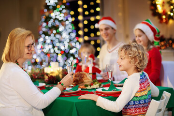 Fototapeta na wymiar Christmas dinner. Family with kids at Xmas tree.