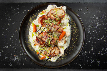 Juicy pork medallions wrapped in bacon, served ith cream souce, baby carrots and sprouts