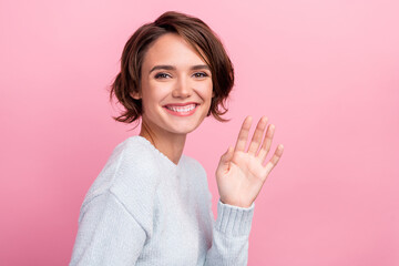 Photo of cheerful happy nice young woman wave hello greeting smile enjoy cool isolated on pink...