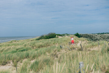 santa claus walking on the dunes direct to the sea holding a deckchair - enjoy the silence moment