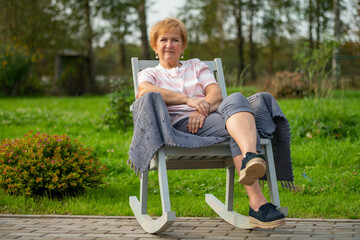 A woman sits in a chair in the fresh air