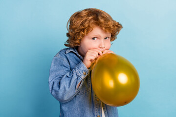 Fototapeta na wymiar Photo portrait curly small boy prepare for birthday celebration inflating air balloon isolated pastel blue color background