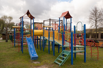 Children's playground with swings, agility equipment, slide and challenge net
