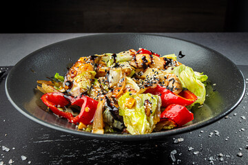 Grilled vegetables with sesame seeds on dark plate