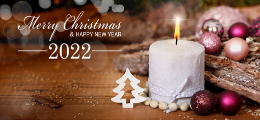 weihnachtskarte mit brennender adventskerze und text merry christmas and happy new year 2022
