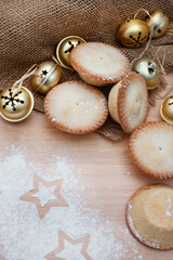 rustic setting with Christmas decorations and fruit mince pies with flour and star shapes