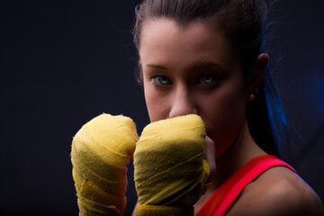 Close-up portrait of woman in boxing hand wraps