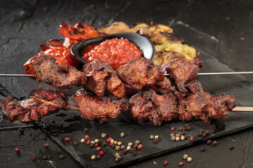 Shashlik or shish kebab preparing on barbecue grill over hot charcoal. Grilled pieces of pork meat on metal skewers.