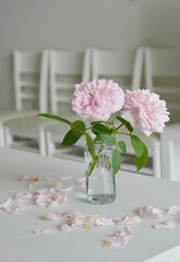 Simple decoration of pastel spirit of freedom roses in a glass jar on banquet table.