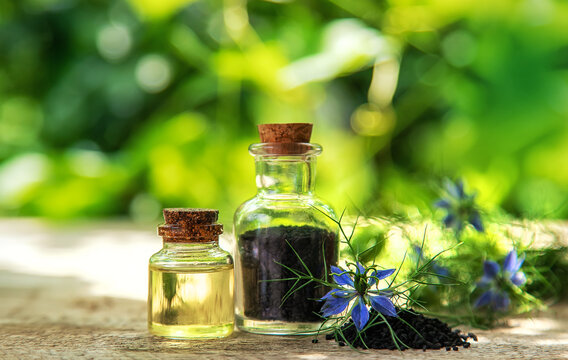 Black cumin oil in a bottle. Selective focus.