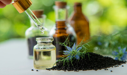 Black cumin oil in a bottle. Selective focus.