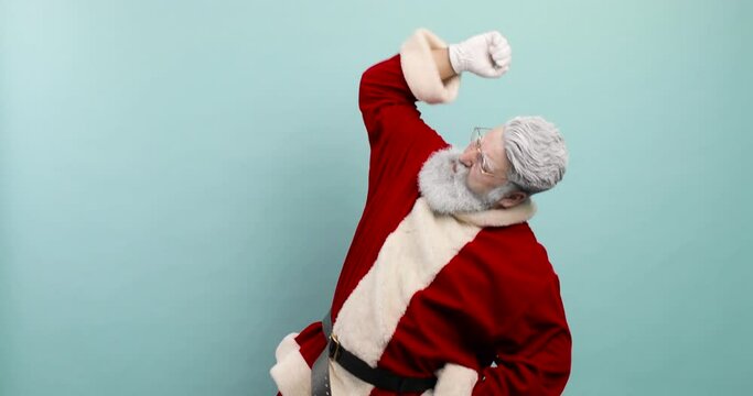 Cheerful dancing trendy santa claus on blue background. Santa claus dancing rodeo, with hand up.