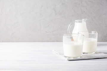 Composition of glass serving vessels with milk. Healthy and dietary food, dairy products. Selective focus. Copy space.