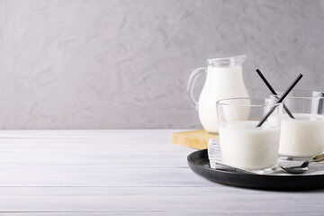 Composition of glass serving vessels with milk. Healthy and dietary food, dairy products. Selective focus. Copy space.