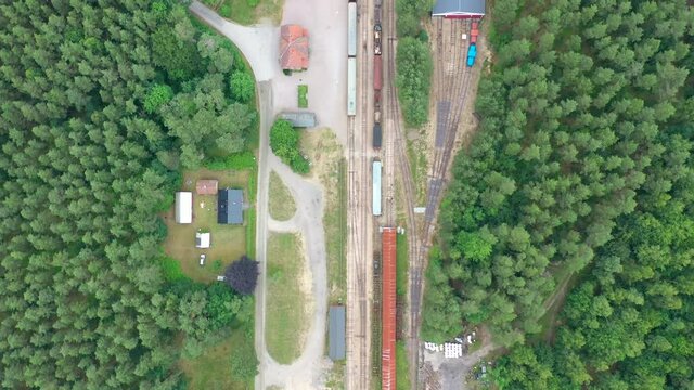 Train yard in a forest, aerial view of tracks, trains & depo