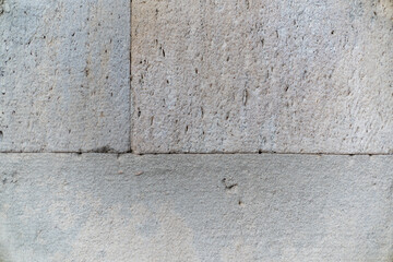 The texture of a rock wall with cracks and scratches that can be used as a background.