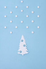 Christmas creative concept. White Christmas tree of paper with snow on the blue background. Holiday concept.