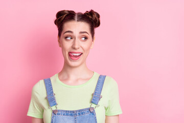 Photo portrait girl with bun licking lips looking copyspace isolated pastel pink color background