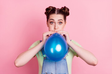 Photo portrait girl in overall inflating air balloon before party isolated pastel pink color background