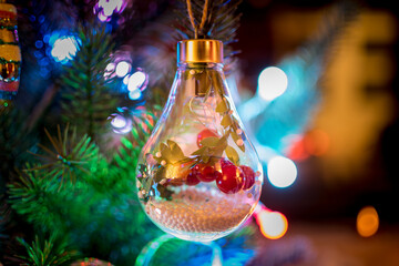 Christmas tree decorations surrounded by colored lights. Christmas items. Christmas ball shaped like a light bulb and decorations inside
