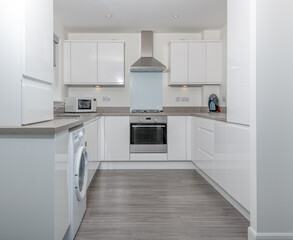Modern Generic New Build Kitchen in High Gloss White and Grey Laminate Link Flooring.