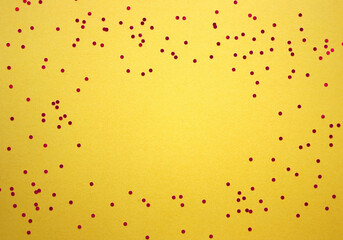 Festive vibrant yellow background with scattered shiny confetti. Copy space for text, greeting. Birthday, party, holiday.
