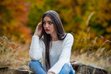 a young brunette with long hair and thin body poses in the autum