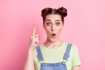 Photo of genius geek girl have idea raise finger open mouth wear jeans overall green t-shirt isolated on pink background