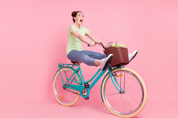 Profile photo of crazy energetic lady careless driver ride bicycle scream wear green t-shirt isolated on pink background