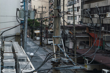 Light poles with cable saturation and air conditioners in makati, manila. Urban view.