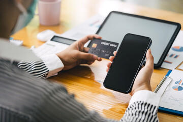 Blank screen mobile, woman hands holding credit card for payment somethings while shopping online.