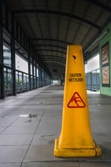 yellow wet ground sign on a covered overpass in Makati City. Urban photography.