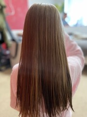 Little kid girl with long hair after shower in a pink robe.