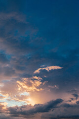 Obraz premium A cloud illuminated by a sun in the evening sky at sunset