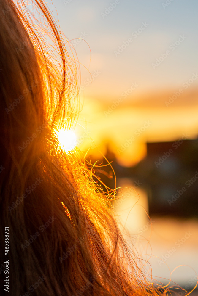 Wall mural sunshine shining through long and curly hair during the golden hour. abstract and calm mood