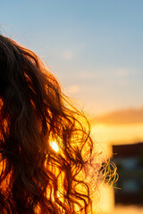 Sunshine shining through long and curly hair during the golden hour. Abstract and calm mood