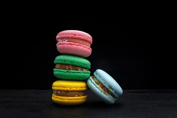 Fototapeta na wymiar four multi-colored homemade natural products macaroon on a black background