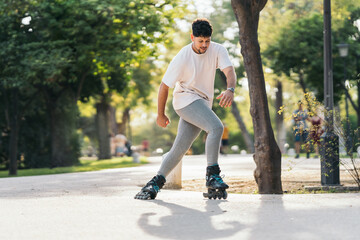 Man skating with inline skates in a paved path of a park