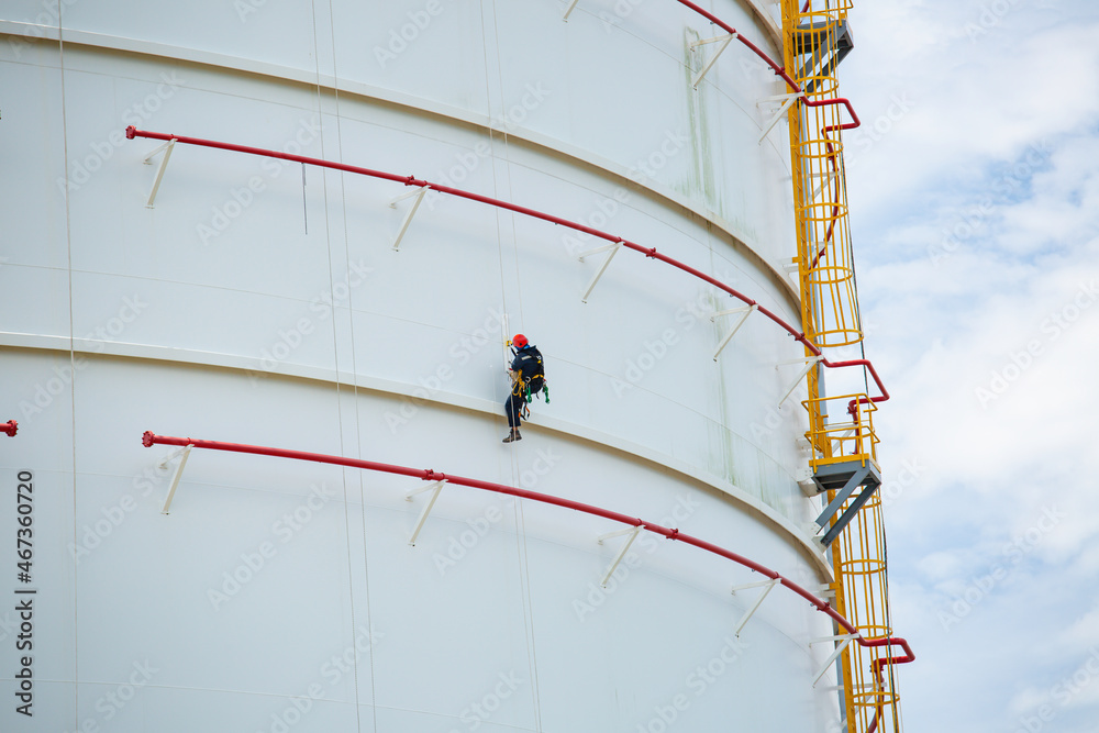 Wall mural Male workers down height tank rope access inspection of thickness shell plate storage tank gas