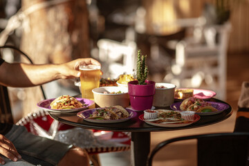 Served traditional Mexican table. Outdoors Food Concept . Unrecognizable group of friends eating mexican food in a restaurant.
