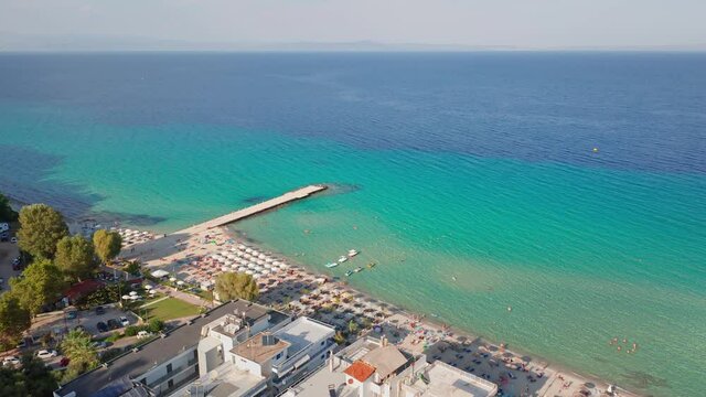 Aerial drone view of Kallithea beach, people, umbrella beach and mount. Halkidiki. Greece