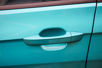 Stylish door handle of a new teal metallic vehicle