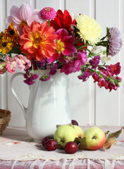 bright bouquet of dahlias in a jug apples and plums