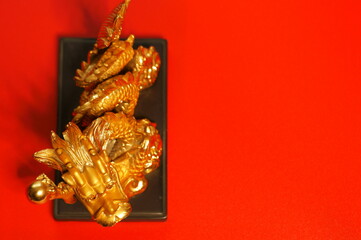 A dragon figurine on a red background. A Chinese symbol of power and supernatural forces.