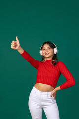 Close-up portrait of young beuatiful girl, student in bright red sweater isolated on green studio backgroud.
