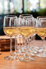 a lot of glasses with white wine in a restaurant at a buffet or banquet for a holiday