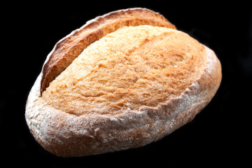 ciabatta of wheat flour is isolated on a black background. Bread, bakery, bun, delicious food