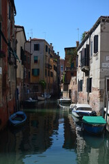 Fototapeta na wymiar The tranquil canals of Venice in the heat of the mid-day sun and summer