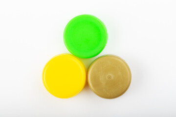 Pile of colored plastic caps on white background. Recycling concept.